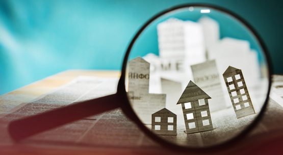 Paper house under a magnifying lens