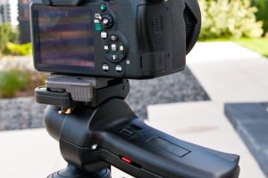 Image of camera on a tripod pointed at a house