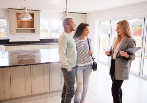 A real estate agent from PLS helping a couple view a new home to potentially purchase